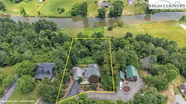 an aerial view of a house with a yard and lake view