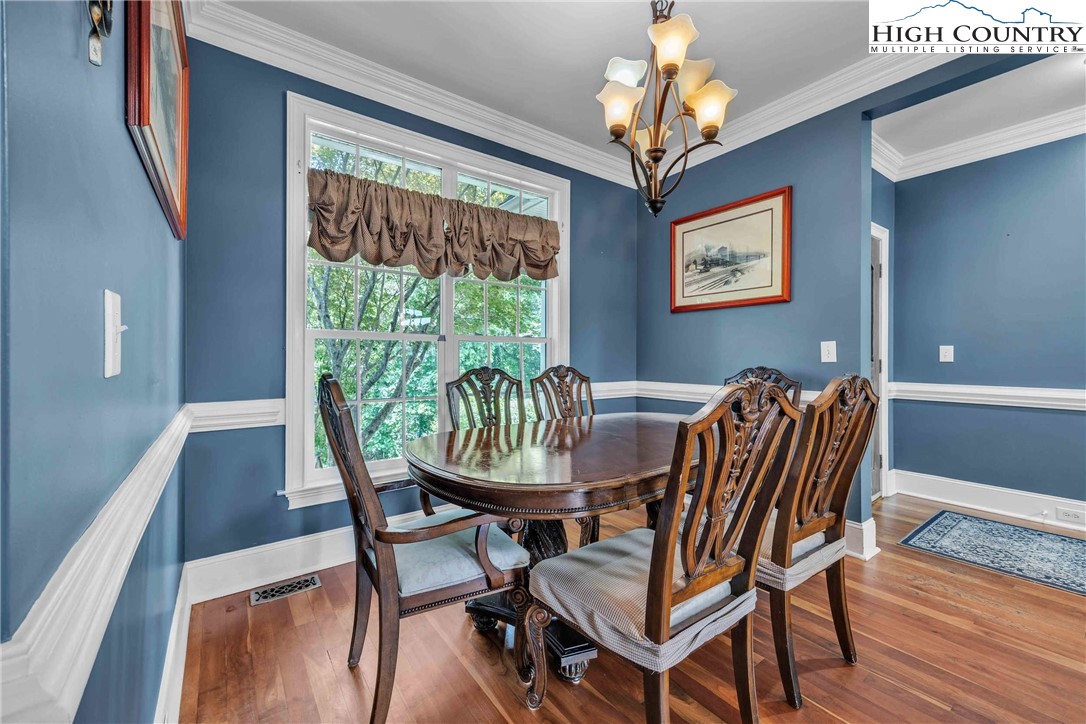 127 Deerfield Road West Jefferson, NC 28694 - Photo 15 of 47 a view of a dining room with furniture wooden floor and chandelier