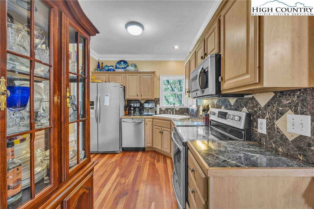 127 Deerfield Road West Jefferson, NC 28694 - Photo 19 of 47 a kitchen with stainless steel appliances granite countertop a refrigerator a stove and a sink with wooden floor