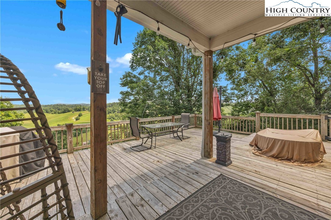 127 Deerfield Road West Jefferson, NC 28694 - Photo 34 of 47 a balcony with wooden floor table and chairs