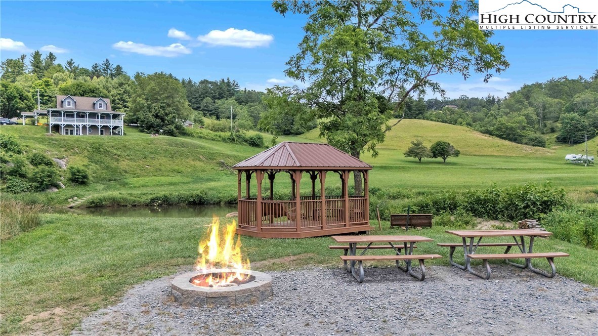 127 Deerfield Road West Jefferson, NC 28694 - Photo 39 of 47 a view of a garden with lawn chairs under an umbrella