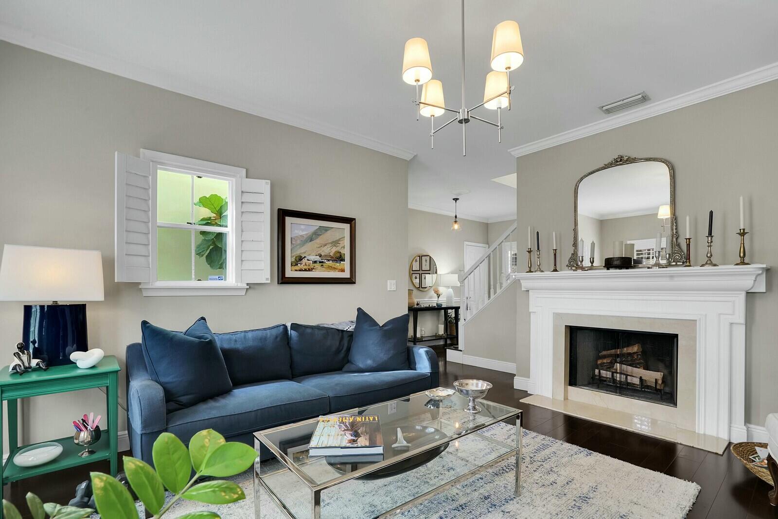 a living room with furniture a chandelier and a fireplace