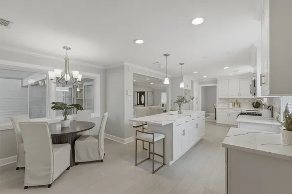 a large white kitchen with a large window and stainless steel appliances