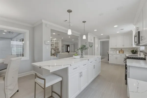 a spacious bedroom with a bed and a chandelier