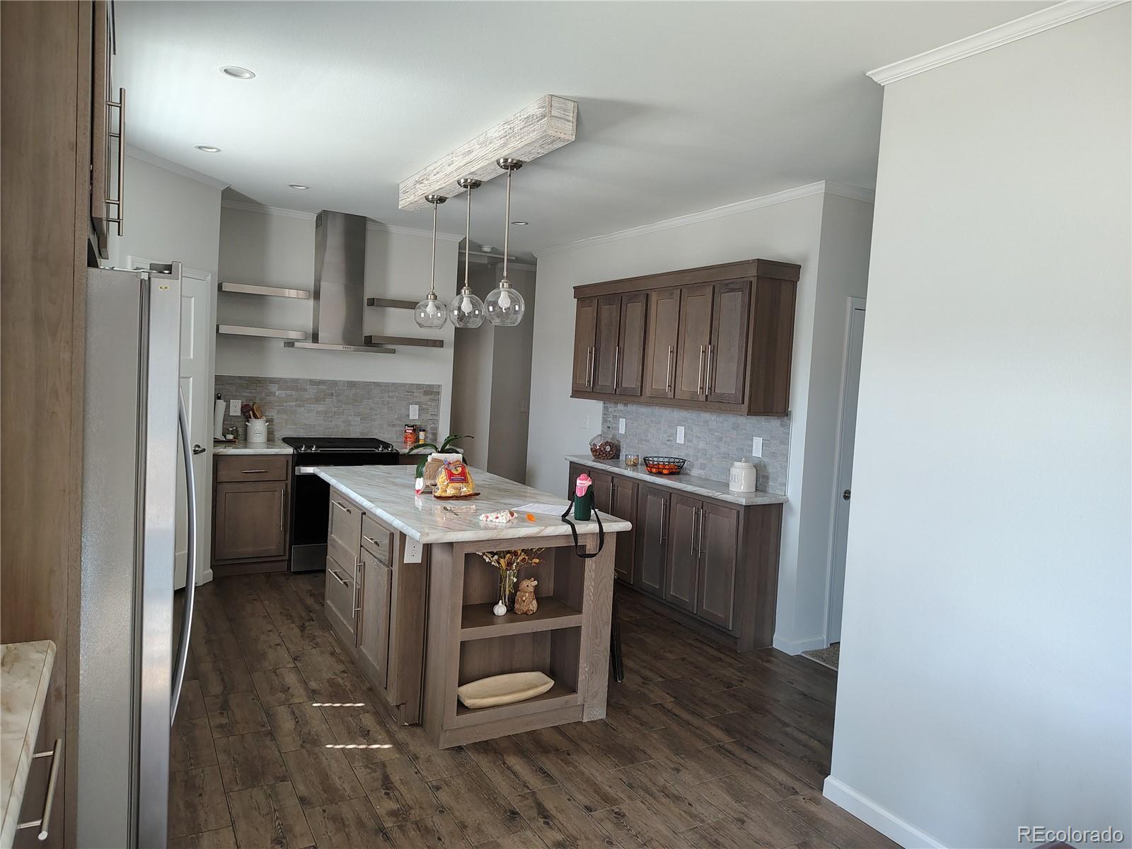 a kitchen with kitchen island a sink stove and refrigerator