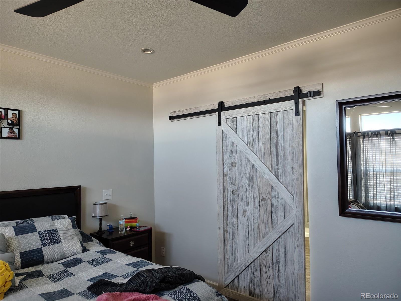 15460 Casler Avenue Fort Lupton, CO 80621 - Photo 10 of 13 a bedroom with a bed and a window