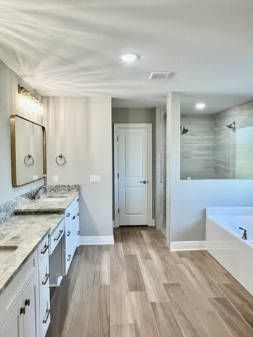 a spacious bathroom with a granite countertop double vanity sink and a mirror