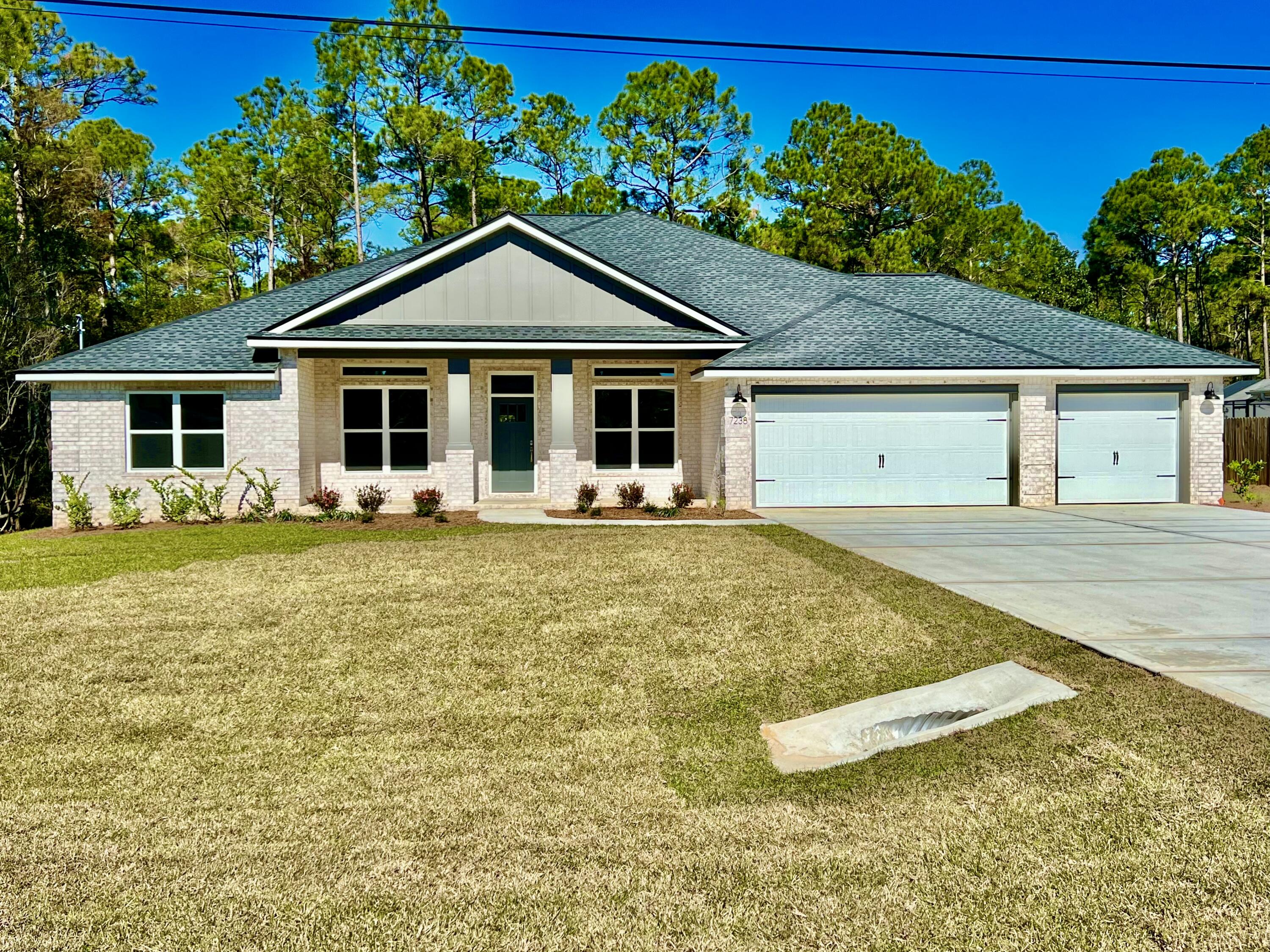 7586 Vinca Street Navarre, FL 32566 - Photo 3 of 44 a front view of a house with garden