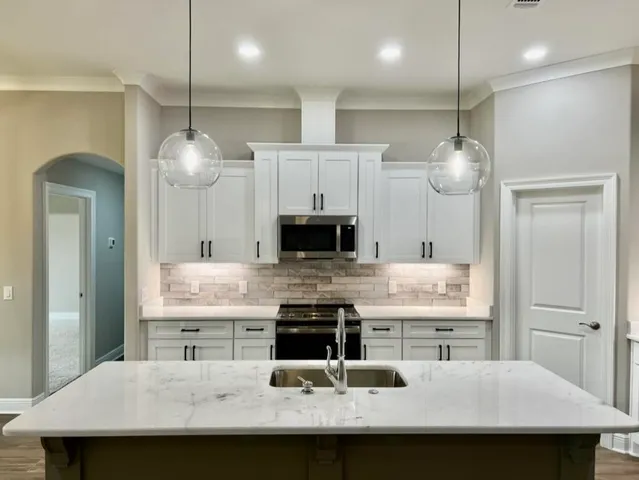 a kitchen with kitchen island a sink stainless steel appliances and cabinets