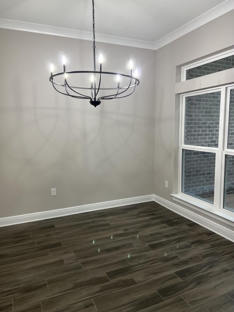 7586 Vinca Street Navarre, FL 32566 - Photo 10 of 44 a view of an empty room with wooden floor cabinets and a window