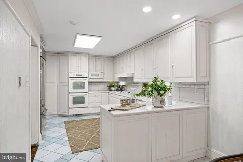 a kitchen with white cabinets and appliances