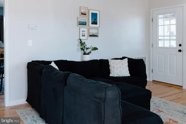 a black leather couch sitting in a living room next to a window
