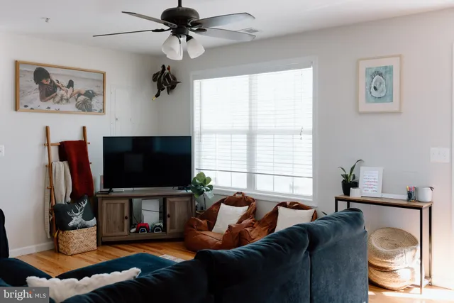 a living room with furniture a flat screen tv and a window