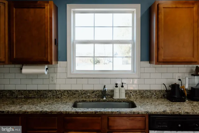 a kitchen with sink a window and cabinets