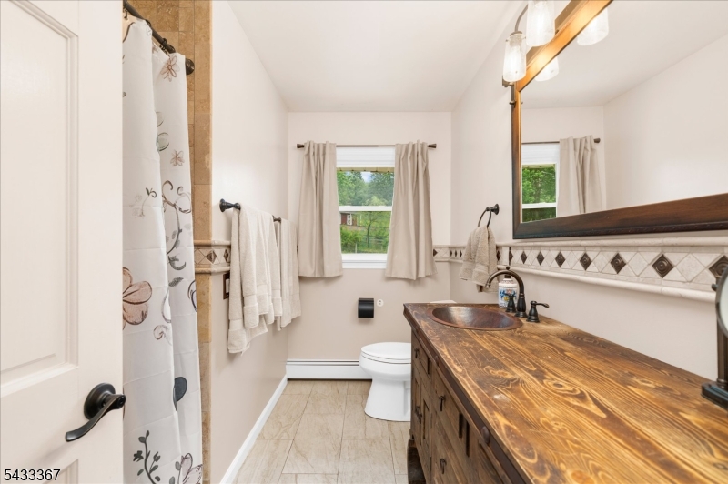 650 Woodglen Road Glen Gardner, NJ 08826 - Photo 13 of 28 a bathroom with a granite countertop sink a toilet a mirror and a bathtub