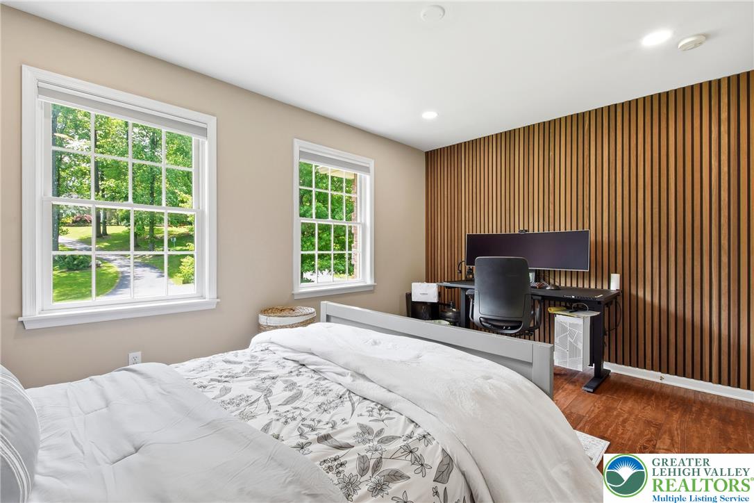 115 West Butternut Road Hellertown, PA 18055 - Photo 49 of 97 Hardwood flooring extends throughout this well-lit bedroom featuring a striking wood-slatted accent wall.