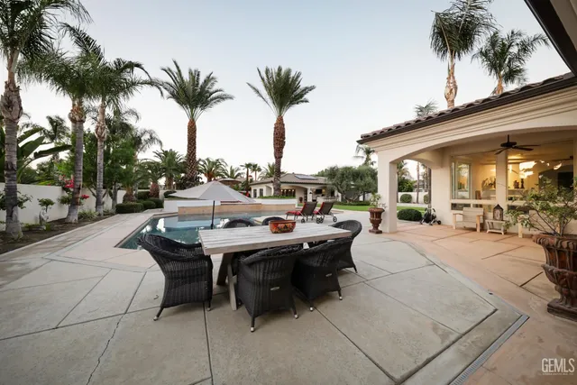a dining room with a table chairs a clock and a ceiling fan