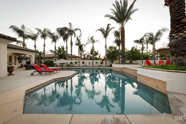 a view of a white house with a swimming pool and a fire pit