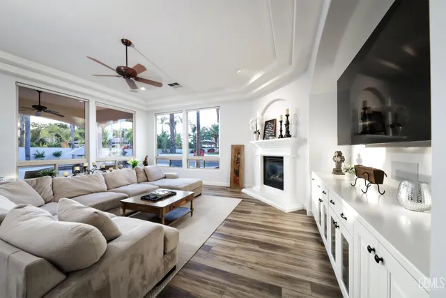 a living room with stainless steel appliances kitchen island a table chairs and a kitchen view