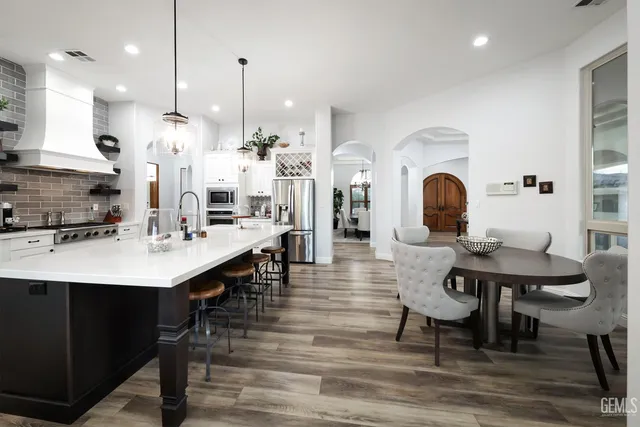 a large kitchen with stainless steel appliances a large counter top