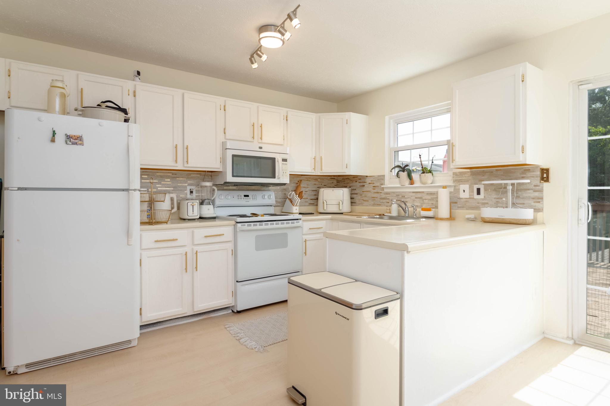 423 Kosoak Road Baltimore, MD 21220 - Photo 5 of 18 a kitchen with white cabinets and white appliances