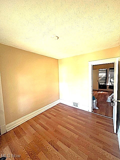 888 Rondel Road Cleveland, OH 44110 - Photo 17 of 35 Empty room featuring a textured ceiling and wood finished floors