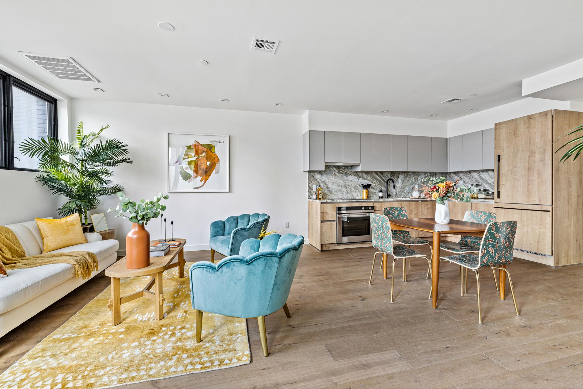a living room with furniture kitchen view and a chandelier
