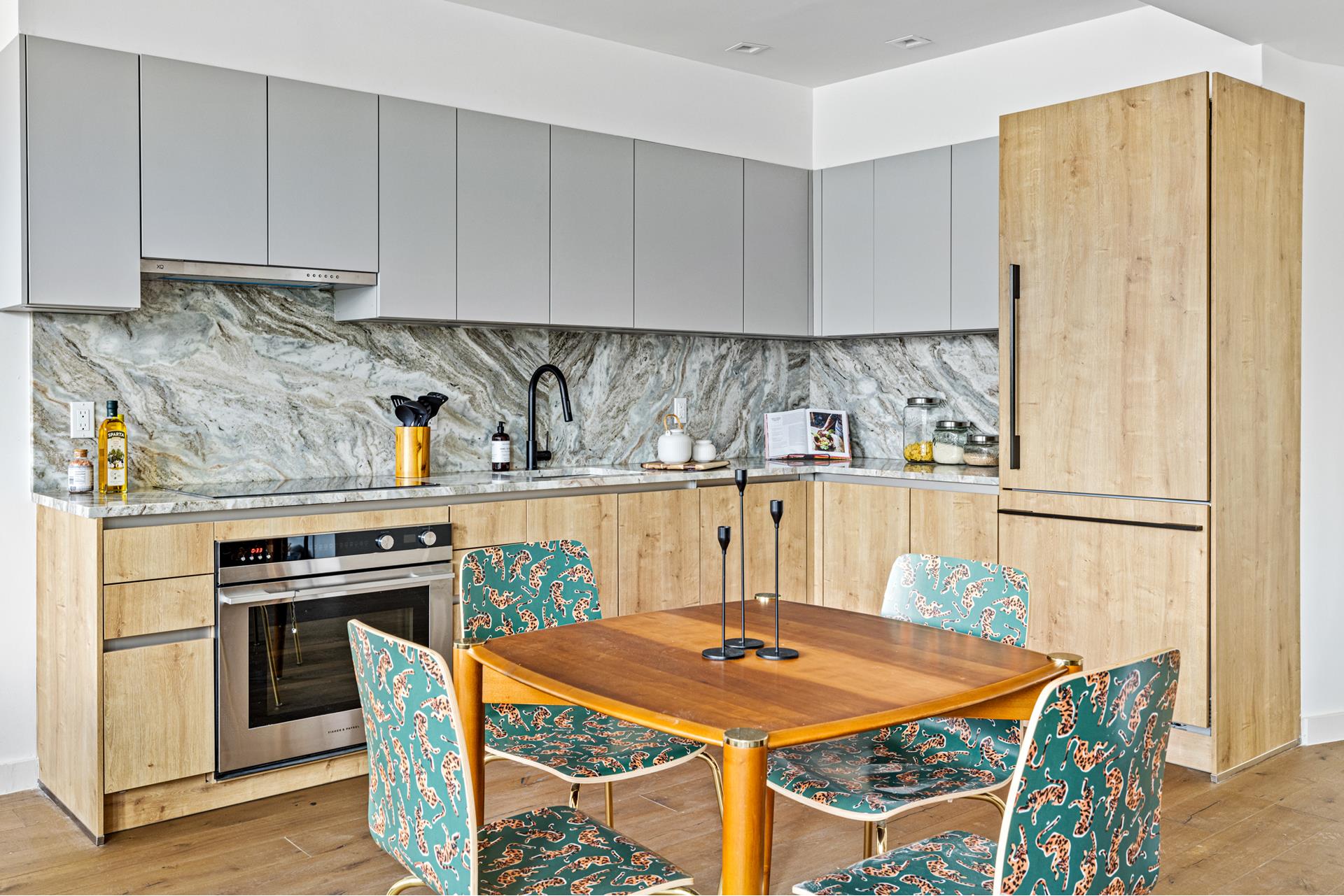 44 Box Street, Unit PHA Brooklyn, NY 11222 - Photo 5 of 18 a kitchen with stainless steel appliances granite countertop a stove a refrigerator a sink a dining table and chairs