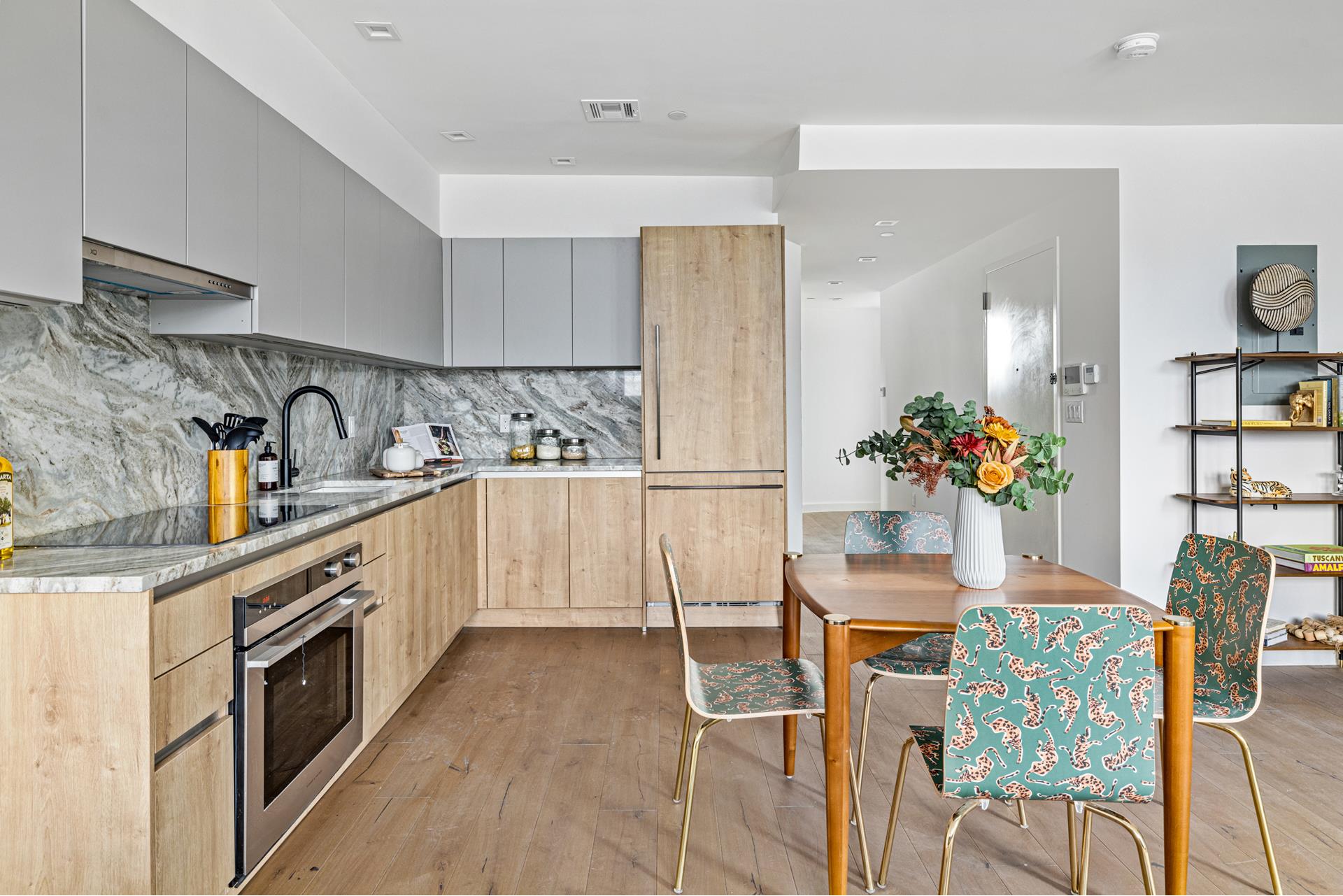 44 Box Street, Unit PHA Brooklyn, NY 11222 - Photo 7 of 18 a kitchen with stainless steel appliances kitchen island granite countertop a table chairs and a refrigerator