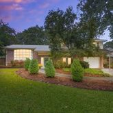 a front view of a house with a yard and tree