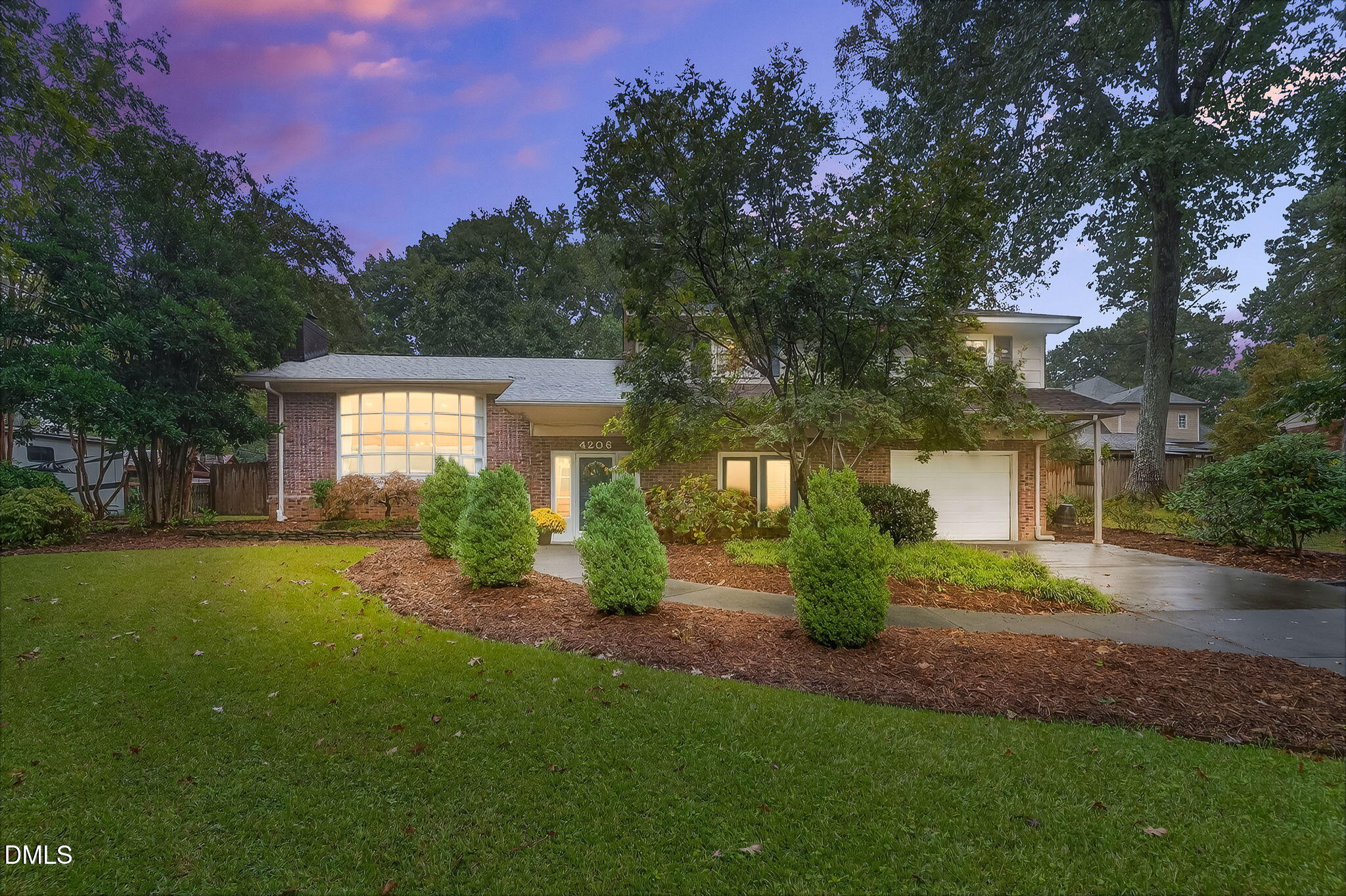 a front view of a house with a yard and tree