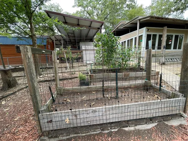 a view of swimming pool with lawn chairs and plants