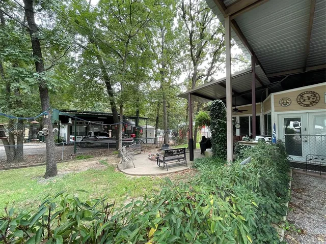 a view of a chairs and table in the patio next to a yard