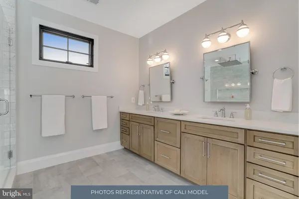 a bathroom with a double vanity sink a mirror and a bathtub