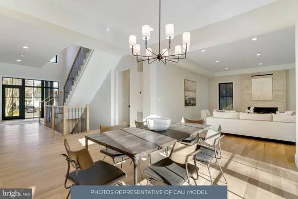 a living room with dining table and a chandelier