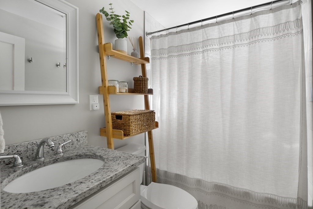 25 Eames Street North Reading, MA 01864 - Photo 10 of 25 a bathroom with a granite countertop sink and a mirror