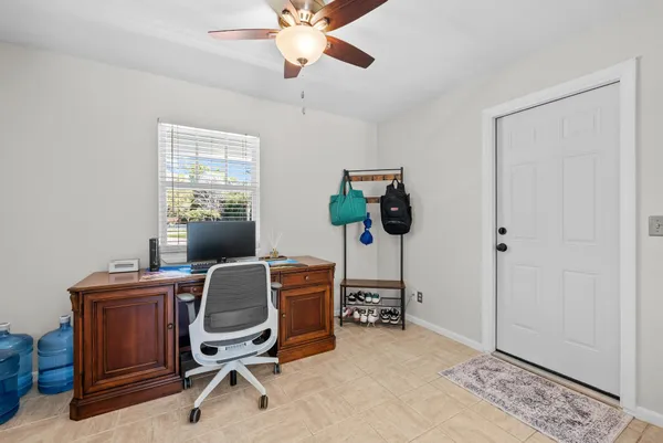 a view of a workspace with furniture and a window