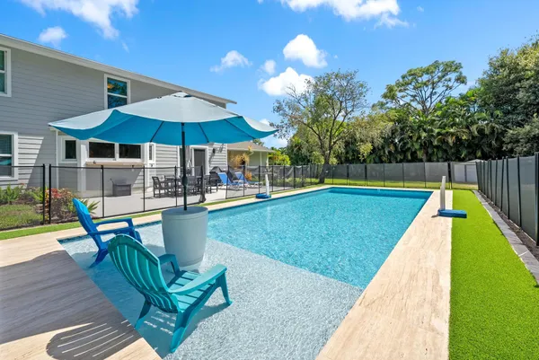 a view of swimming pool with lounge chairs in patio