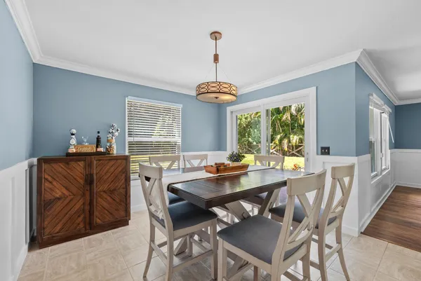 a dining room with furniture a chandelier and window