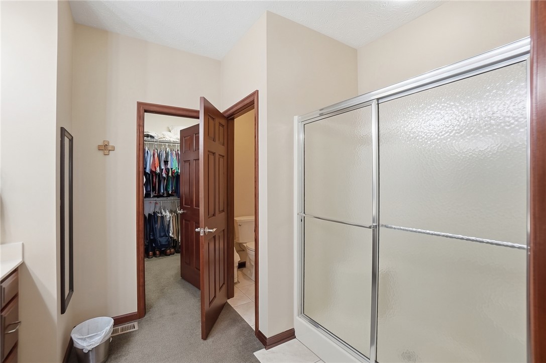 710 Governors Road Troy, OH 45373 - Photo 20 of 56 This primary bathroom features a functional walk-in closet and a shower with sliding doors.