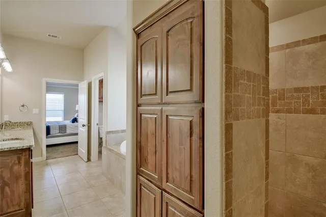 a spacious bathroom with a granite countertop tub sink and mirror