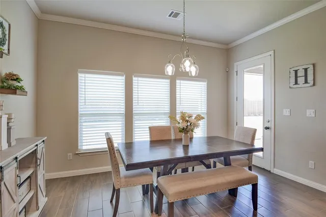a view of a dining room with furniture wooden floor and chandelier