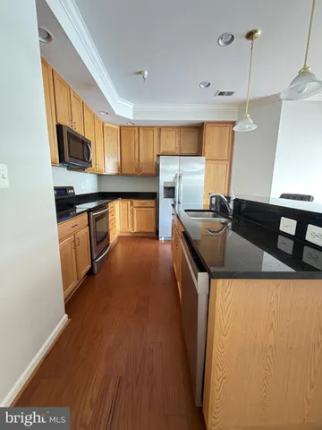 a kitchen with stainless steel appliances granite countertop a sink a stove and a refrigerator