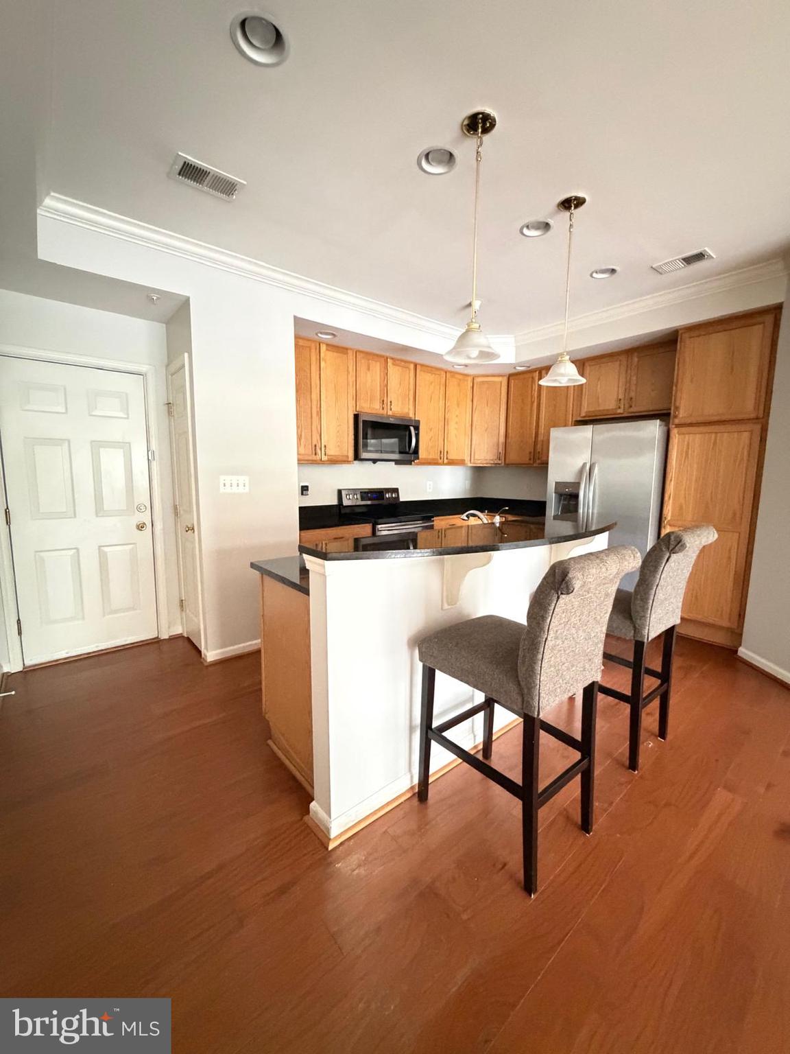 7248 Elkridge Crossing Way Elkridge, MD 21075 - Photo 6 of 47 a kitchen with stainless steel appliances granite countertop a table chairs and a refrigerator