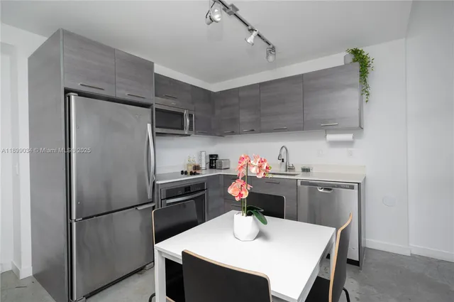 a kitchen with kitchen island a counter space a sink appliances and cabinets