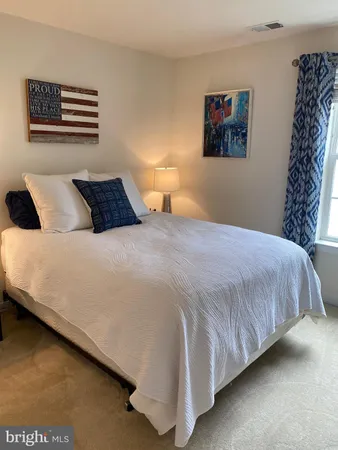 a bedroom with a bed and a painting on the wall