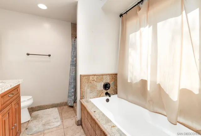 a spacious bathroom with a tub sink and mirror