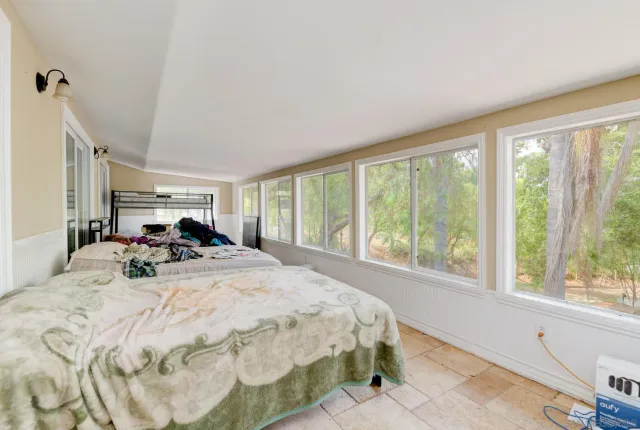 a bed sitting in a spacious bedroom next to a window