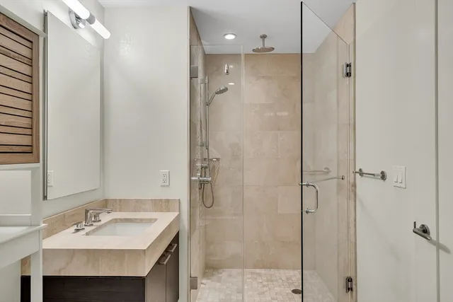 a bathroom with a granite countertop sink shower and a mirror