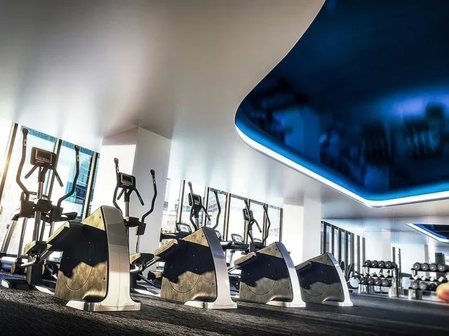 a room with lots of white furniture and gym equipment